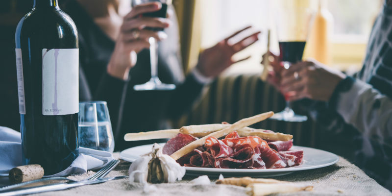 Se puede pensar dónde sentarse, ya que los que están en los extremos de la mesa suelen tener menos acceso a los entrantes, bandejas, cestas de pan... (iStock)