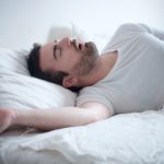 ¿Qué es la apnea? Man sleeping in his bed and snoring loudly