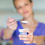 Por qué sí puedes (y debes) tomar yogurt si no toleras bien la lactosa Mujer tomando yogurt